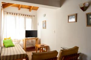 a living room with a couch and a tv at Cabañas Naxara in Villa La Angostura