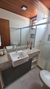 un bagno con lavandino, WC e specchio di Lindo Villaggio em Barra Grande a Barra Grande Altre 33 foto
