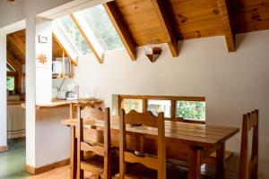 a kitchen and dining room with a wooden table and chairs at Cabañas Naxara in Villa La Angostura