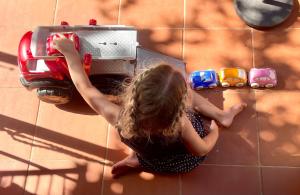 a young girl is playing with a toy truck at Agriturismo Vernianello in Poggibonsi