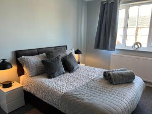 a bedroom with a bed with gray pillows and a window at Oakfield Apartment in Brumby