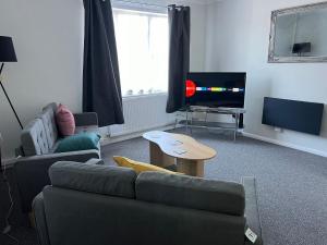 a living room with a couch and a tv at Oakfield Apartment in Brumby