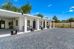 a white house with a gravel driveway at Coralinas Beach Apartments in El Combate