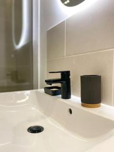 a bathroom sink with a black faucet on it at Au cœur de Bourges in Bourges +22 photos