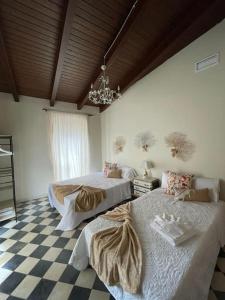 a bedroom with two beds and a chandelier at Casa Rural 3R Completa in Don Álvaro +8 photos