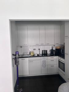 a kitchen with white cabinets and a sink at Apartment Basel in Basel