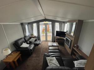 an overhead view of a living room with leather furniture at Lake District Stunning Lodge in Plumbland