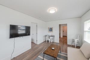 a living room with a couch and a tv at #StayInMyDistrict Bluebird Cottage Coos Bay in Coos Bay