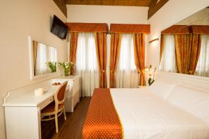 a bedroom with a bed and a desk and window at Casanova Fourrooms in Venice