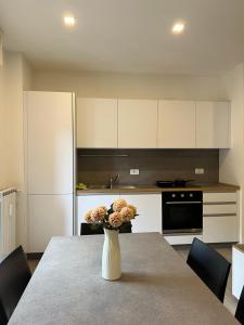 a kitchen with a table with a vase with flowers on it at Bernina View in Tirano