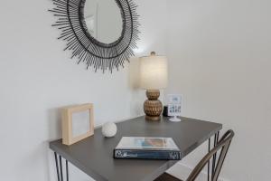 une table avec une lampe et un miroir mural dans l'établissement #StayinMyDistrict Coos Bay Goldfinch Cottage, à Coos Bay