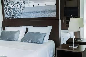 a bedroom with a bed with a picture on the wall at Bonaparte Hotel - Excelente Apartamento#417 in Brasilia