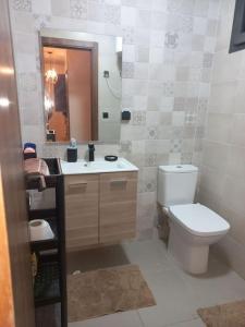 a bathroom with a toilet and a sink and a mirror at Appart familial près de la plage Val d'or in El Harhoura