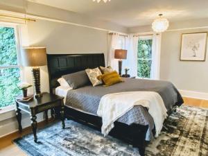 a bedroom with a bed and a table and windows at Historical Entertainer 3 Bedroom Townhouse AC PNW in Albany