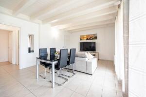 a living room with a table and chairs and a couch at GardalandLuxuryApartment Pool & Free Parking in Ronchi