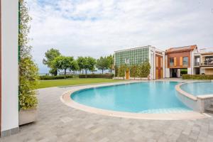 a large swimming pool in a yard with a building at [Gardaland_Luxury_Apartment] Pool & Free Parking in Ronchi