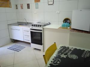 a kitchen with a stove and a sink and a table at Yellowkits in São Paulo
