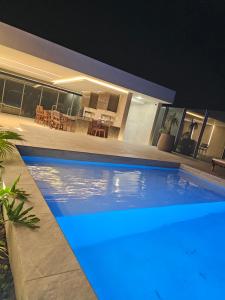 a swimming pool in front of a house at night at Departamento de lujo en EQUIPETROL in Santa Cruz de la Sierra