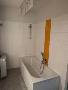 a bathroom with a bath tub with an orange stripe at Hinter der Alten Post in Annaberg-Buchholz +12 photos