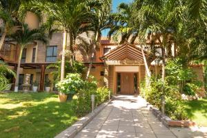 a house with palm trees and a walkway at Casa Verano Beach Hotel - Adults Only in Santa Marta