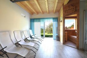 a row of white chairs in a room with a window at Baita Tersilia Near Lake And Mountain Veneto in Pranòtz
