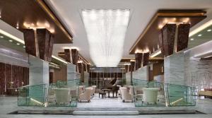 a lobby of a hotel with tables and chairs at Atana Hotel in Dubai