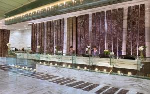 a lobby of a hotel with people standing in the lobby at Atana Hotel in Dubai