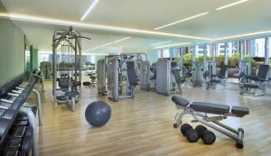 un gimnasio con cintas de correr y máquinas en un edificio en Atana Hotel, en Dubái