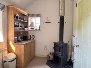 a kitchen with a stove in the corner of a room at Birds Nest in Gatehouse of Fleet