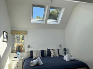 a bedroom with a blue bed with two windows at Birds Nest in Gatehouse of Fleet +9 photos