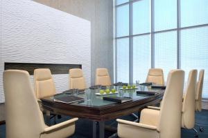 a conference room with a wooden table and chairs at Atana Hotel in Dubai