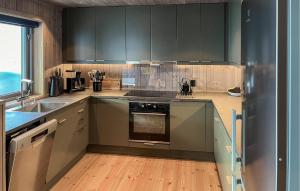 a kitchen with gray cabinets and a stove top oven at Gorgeous Home In Aurdal With Wifi in Aurdal