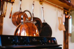 a copper tea kettle sitting on top of a stove at Wagon & the Wigwam in Four Marks