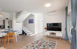 a white living room with a dining table and a tv at Lovely Home In Pasman in Pašman