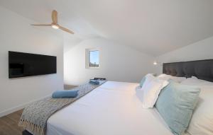 a bedroom with a large white bed with a flat screen tv at Lovely Home In Pasman in Pašman +38 photos