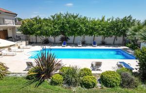 PoličnikにあるVilla Tonaの椅子と木々のある庭のスイミングプール