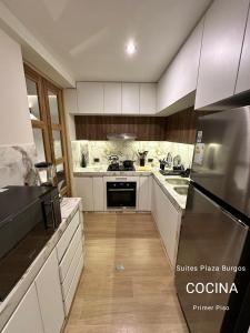 a kitchen with white cabinets and a stainless steel refrigerator at Suites Plaza Burgos in Chachapoyas +10 photos