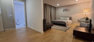 a bedroom with a bed and a chair and a desk at Confortável ensuite 1 privado centro da cidade in Póvoa de Varzim