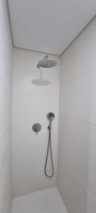 un bagno bianco con doccia e soffione di Confortável ensuite 1 privado centro da cidade a Póvoa de Varzim