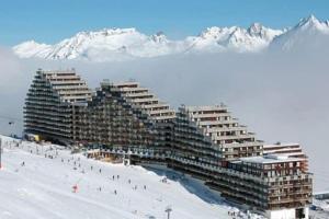 a large building on top of a snow covered mountain at Appartement Chic et Cosy in Aime-La Plagne