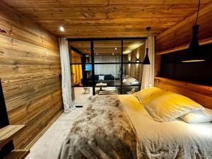 a bedroom with a bed in a room with wooden walls at Appartement Chic et Cosy in Aime-La Plagne
