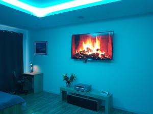 Televízia a/alebo spoločenská miestnosť v ubytovaní Apartament Tęczowy