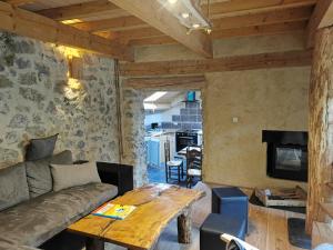 a living room with a couch and a table at Gîte de ferme équestre in Auzet