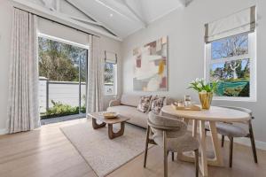 a living room with a couch and a table at The Olive Cottage in Constantia in Cape Town