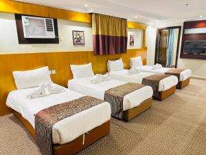 a hotel room with four beds in a room at فندق ام جي كراون 3 - MG Crown Hotel 3 in Medina +88 photos