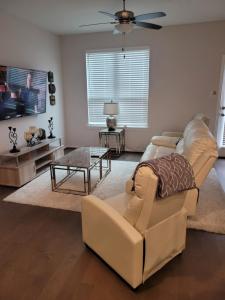 a living room with a couch and a tv at Ts3 Houston in Missouri City
