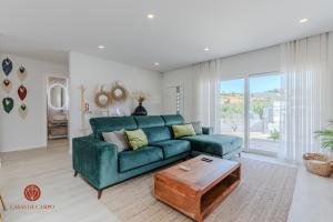 a living room with a green couch and a table at Casas de Campo - Vale da Terça in Vermelha