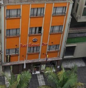Ein orangefarbenes Gebäude mit Leuten, die draußen stehen. in der Unterkunft Hotel Bolivar Plaza in Manizales