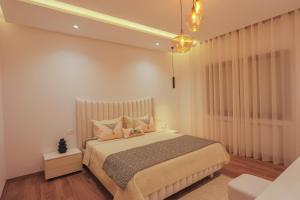 a bedroom with a large bed with pillows at Bright and Cozy New 3 Bedrooms Apartment in Tunis