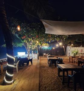 a restaurant with tables and lights at night at The Coco Leaf Cafe in Gokarna